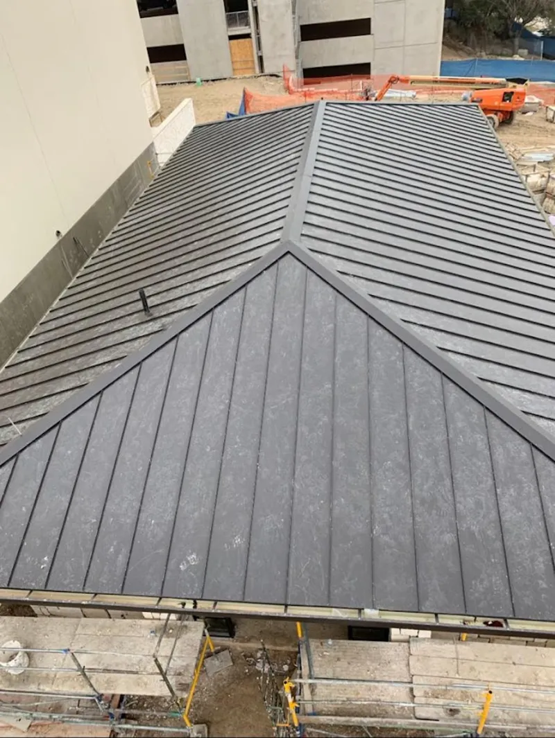 Commercial metal roof construction with crane equipment in Babylon